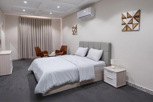 a bedroom with a large bed and two chairs at The view apartment -studio 1 in Al Baha