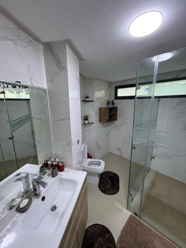 a bathroom with a sink and a shower and a toilet at Villa Marrakech Rouge in Aït Zat