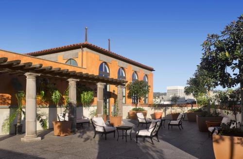 a patio with chairs and tables in front of a building at Plaza la Reina in Los Angeles