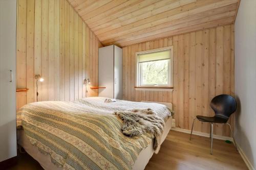 a bedroom with a bed and a chair in it at C11323-Tarm-Brombaervej-8 in Tarm