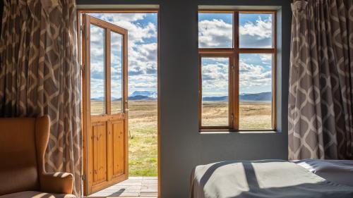 a bedroom with a bed and a window with a view at Fjalladýrð Hotel in Modrudalur