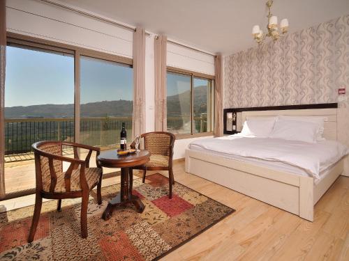 a bedroom with a bed and a table and chairs at White Suites in Majdal Shams