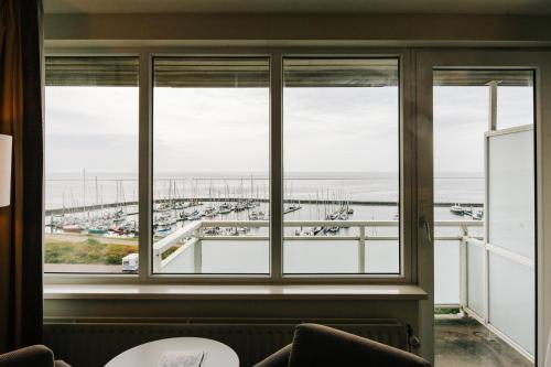 a window in a room with a view of a harbor at WestCord Hotel Schylge in West-Terschelling