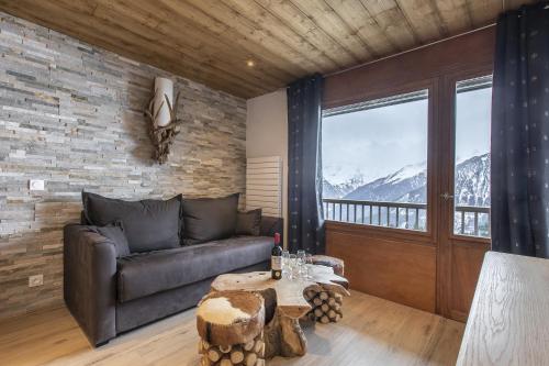 a living room with a couch and a table at Résidence La Forêt Du Praz - Courchevel 1850 in Courchevel