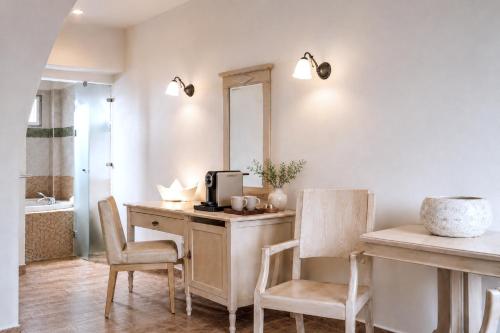 a kitchen with a desk and chairs and a mirror at Lagos Mare Hotel in Agios Prokopios