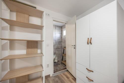 a small bathroom with white cabinets and a walk in closet at Sunwaves 2 - Casa Oasis in El Palmar