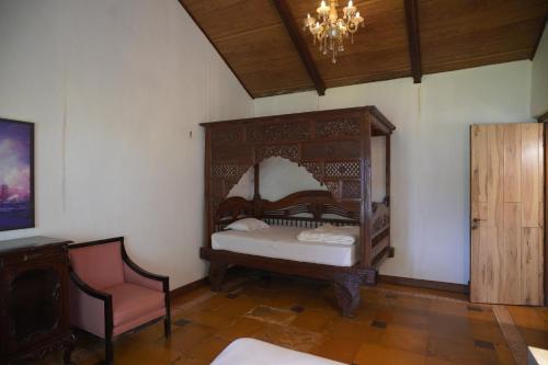 a room with a bed and a chair and a chandelier at White Castle in Malavli