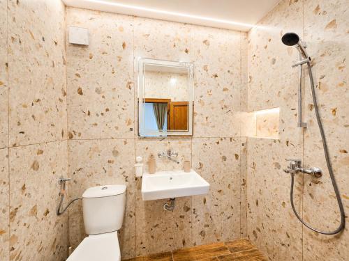 a bathroom with a toilet and a sink and a shower at Kazlarov Guest House in Kiten