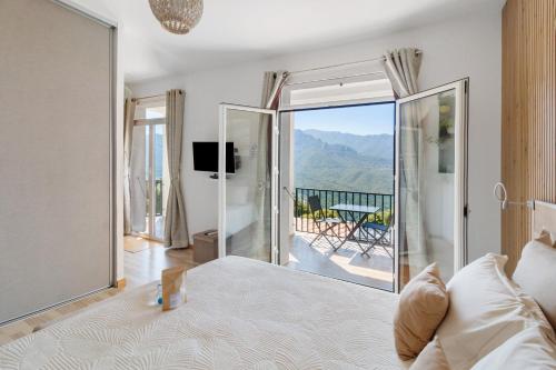 a bedroom with a bed and a balcony with a view at Douce Heure & Saveurs in Tavaco