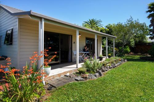 a woman sitting on the porch of a house at Modern-Immaculate-Spacious-Comfy Beds-Private in Westport