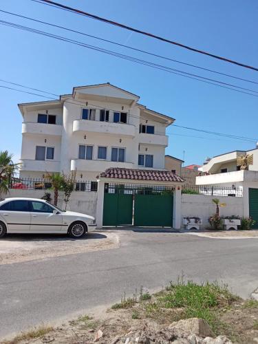 a white car parked in front of a house at Rooms New DiamonD in Durrës