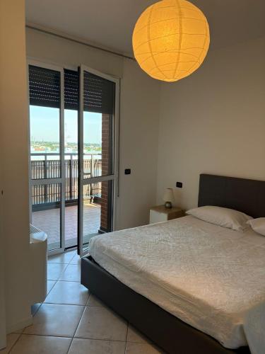 a bedroom with a bed and a view of a balcony at La CASA DI ALE in Imola