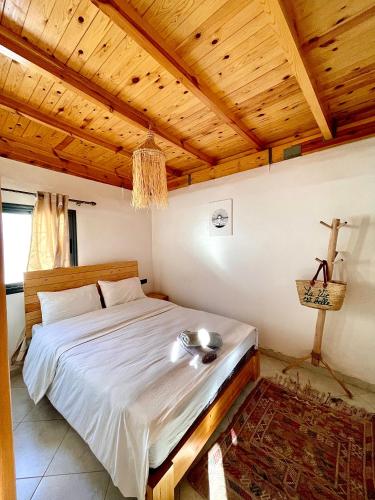 a bedroom with a bed with a wooden ceiling at Arinas Surf Hostel in Taghazout