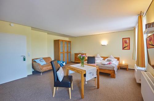 a hotel room with a bed and a table at Strandwetter Dünenhotel in Borkum