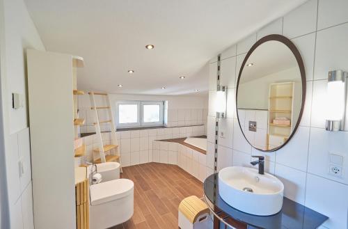 a bathroom with a sink and a mirror at Strandwetter Dünenhotel in Borkum