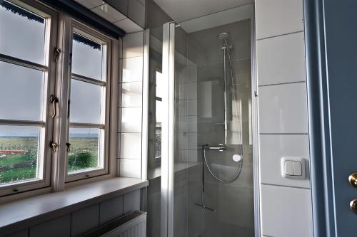 a bathroom with a shower and a window at Haus Nordmarsch in Langeneß