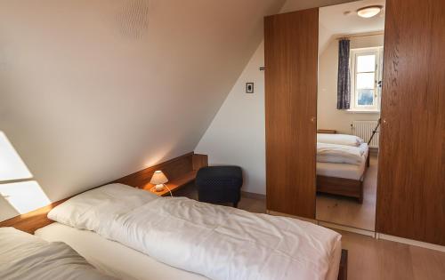 a small bedroom with two beds and a window at Haus Nordmarsch in Langeneß