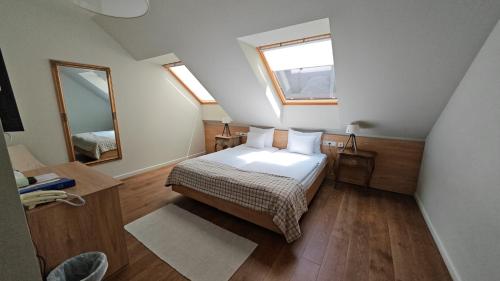 a small bedroom with a bed and a mirror at Újhuta Kastélyszálló in Háromhuta