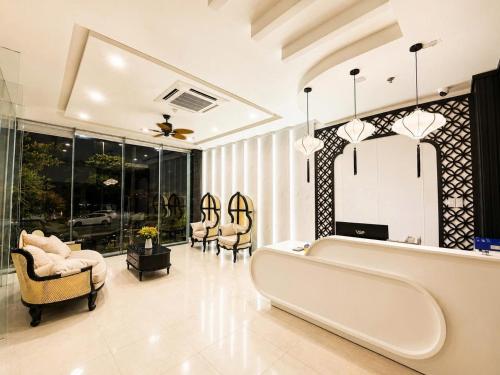 a living room with a large couch and chairs at Asteria Ocean Residence in Danang