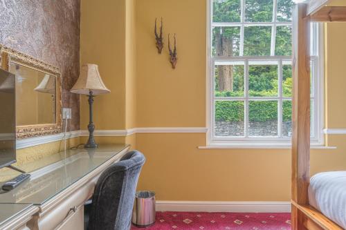 a bedroom with a desk and a window at Lonsdale House in Bowness-on-Windermere