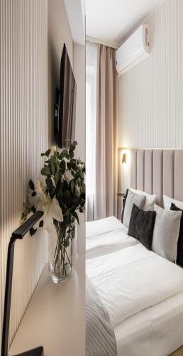 a bedroom with a bed with a vase of flowers on a table at Hotel Delta in Krakow