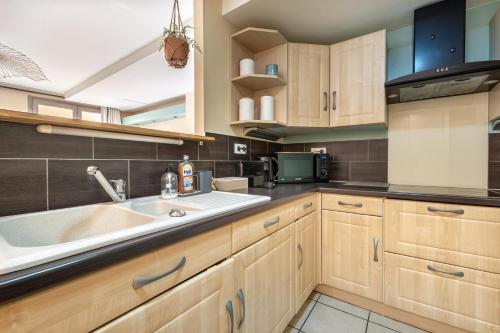 a kitchen with wooden cabinets and a sink at La suite de L'Evêché in Limoges