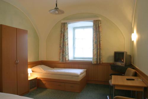 a bedroom with a bed and a window at Pension Schererhof in Pliening