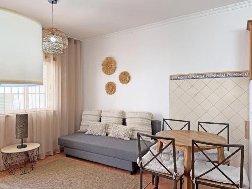 a living room with a couch and a table at Casa Formosinha Cabanas Beach in Cabanas de Tavira