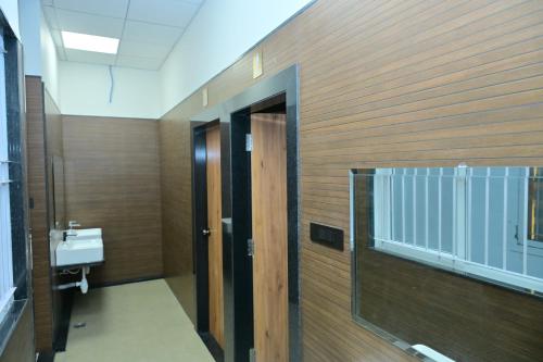 a bathroom with a toilet and a sink and a door at BHAVANIS Vista By ICON in Hosūr