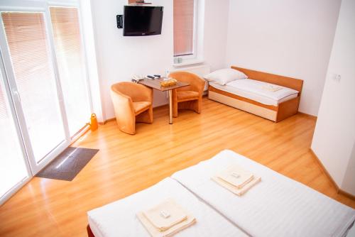 a room with a bed and a table and a bed at Mliečna víla in Turčianske Teplice