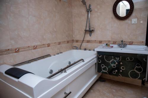 a bath tub and a sink in a bathroom at UNPLAN Kathmandu in Kathmandu