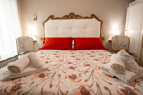 a bedroom with a large bed with towels on it at Ancora Apartments in Marina di Massa