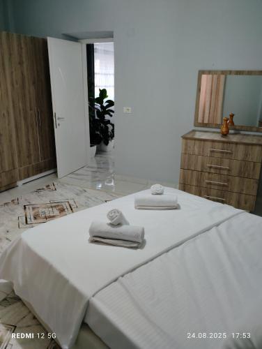 a bedroom with a white bed with towels on it at Vila Marini in Lin