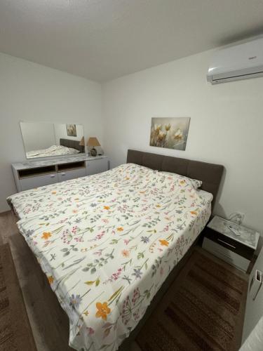 a bedroom with a bed with a floral comforter at Apartment & Apartment Studio Deželjin in Senj