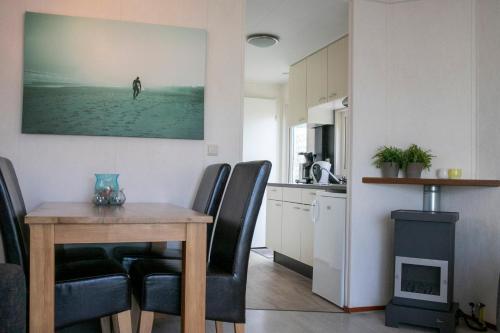a kitchen and dining room with a table and chairs at Chalet nr 43 in Molkwerum