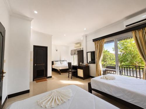 a bedroom with two beds and a living room at Champs Elysees Boutique Hotel in Phumĭ Réach Born (2)