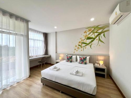 a bedroom with a bed and a plant on the wall at Lueangchan Orchid Hotel in Chanthaburi