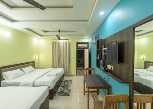 a hotel room with two beds and a table at Hotel Almora Palace in Almora