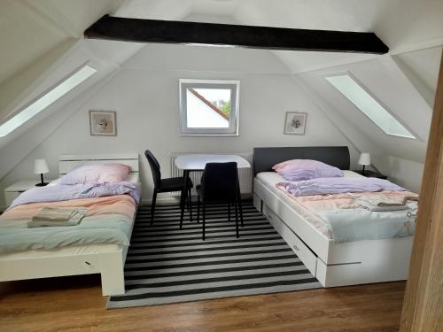 a attic bedroom with two beds and a table at Ferienwohnung Schießstatt in Bad Saulgau