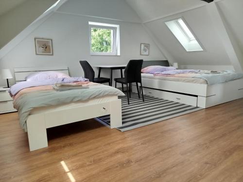 two beds in a room with a table and chairs at Ferienwohnung Schießstatt in Bad Saulgau