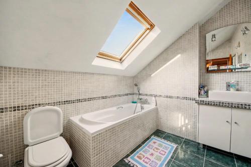 a bathroom with a tub and a toilet and a window at Casa Na Aldeia in Arões