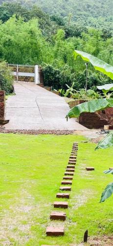 a set of wooden steps in a field of grass at Vaidic Yoga Retreat in Ponsuli