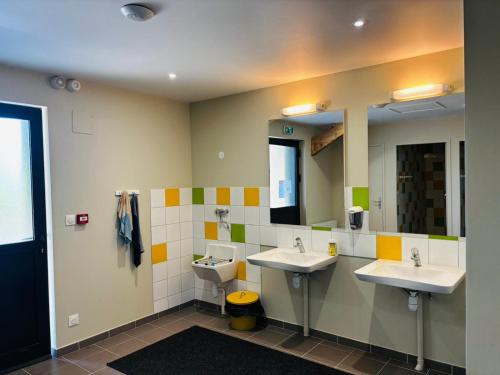 a bathroom with two sinks and two mirrors at Ecodomaine Chemins de Traverse in Auberive