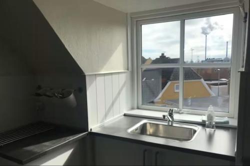 a kitchen with a sink and a window at Svanegade 1 , 2 sal in Thyborøn