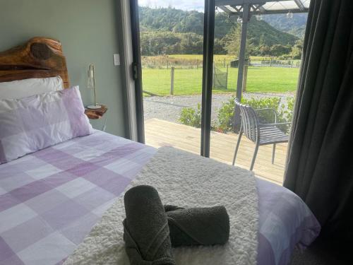 a bedroom with a bed and a view of a patio at Robbies Hut in Greymouth