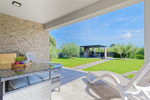 a patio with white chairs and a table and a gazebo at Villa Tea by Rent Istria in Umag