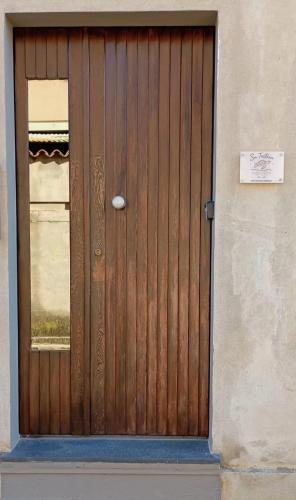 a wooden door on a building with a sign on it at Su Tostoiu alloggio privato in Càbras