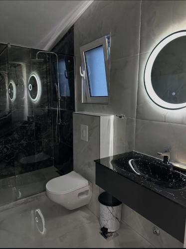 a bathroom with a toilet and a sink and a mirror at Martin Apartments in Gornji Štoj