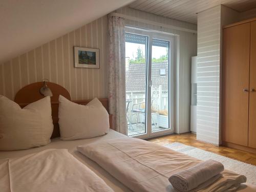 a bedroom with a bed and a large window at Pension Zimmermann in Unteruhldingen