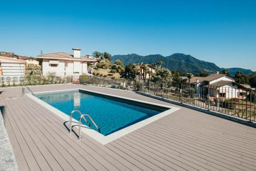 a swimming pool on top of a wooden deck at Appartamento Meda - Lakeside Leisure & Business in Cissano